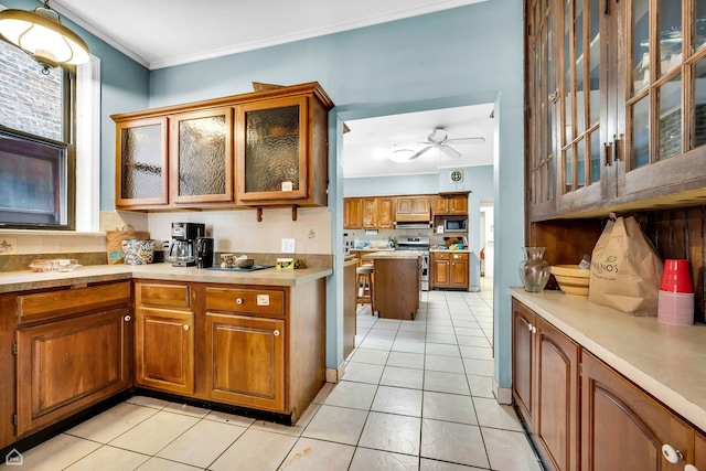 1347 E Hyde Park Blvd, Chicago, IL 60615 - kitchen with stainless steel appliances, brown cabinetry, light tile patterned floors, ceiling fan, and crown molding