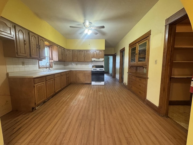 2439 S 57th Ave, Cicero, IL 60804 - kitchen featuring white stove, light wood-type flooring, light countertops, backsplash, and ceiling fan