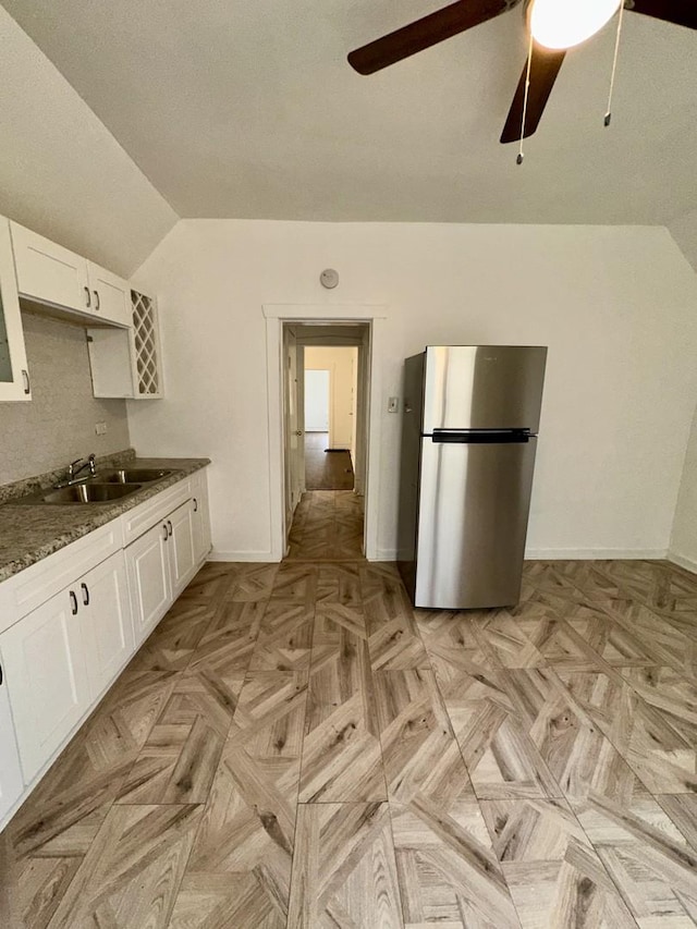 10749 S State St, Chicago, IL 60628 - kitchen featuring freestanding refrigerator, a sink, vaulted ceiling, a ceiling fan, and white cabinetry