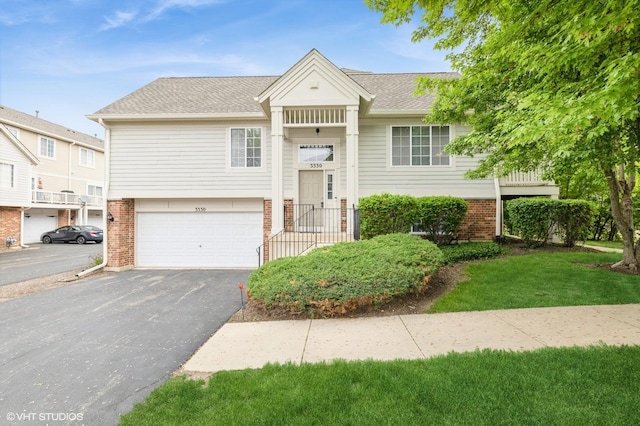 3330 Cameron Dr Unit 17-1, Elgin, IL 60124 - view of front facade featuring brick siding, asphalt driveway, an attached garage, a shingled roof, and a front yard