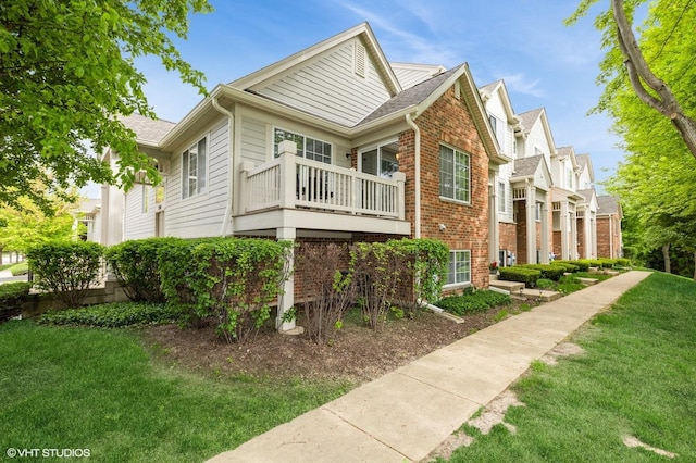 3330 Cameron Dr Unit 17-1, Elgin, IL 60124 - view of property exterior with brick siding, a lawn, a balcony, and roof with shingles