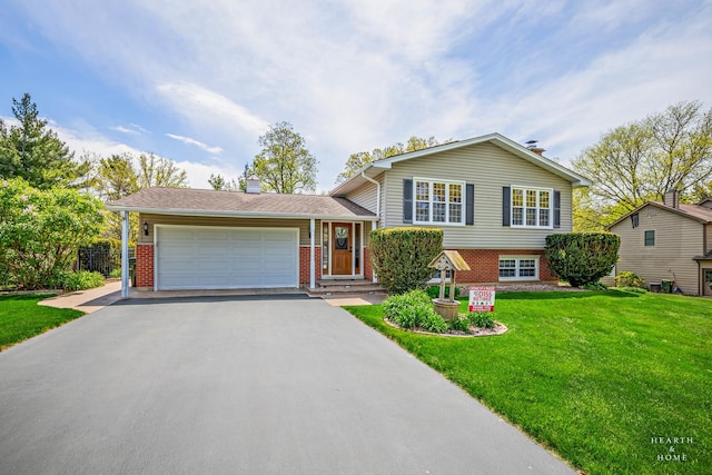 split level home featuring asphalt driveway, brick siding, a front lawn, and a garage