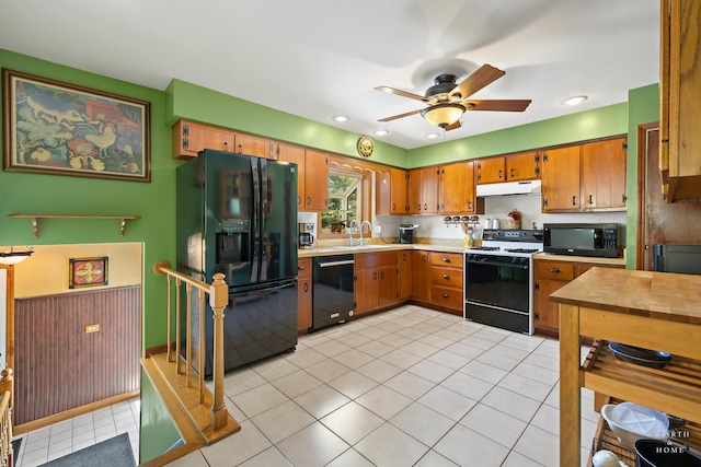 kitchen with black appliances, under cabinet range hood, light countertops, ceiling fan, and brown cabinets