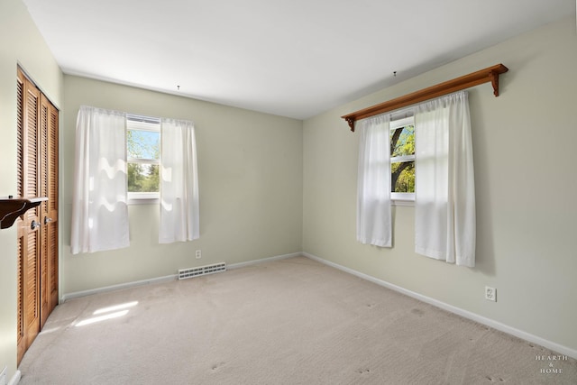 carpeted spare room featuring baseboards