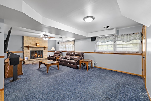 carpeted living area with baseboards, ceiling fan, and a large fireplace
