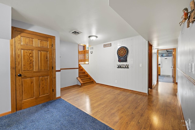 spare room featuring wood finished floors, stairway, and baseboards