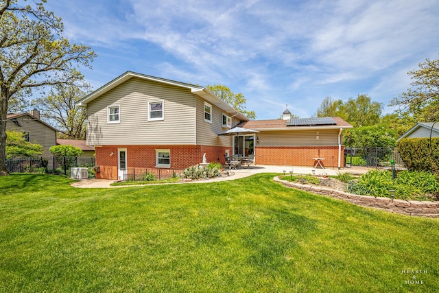 back of property featuring brick siding, a patio area, solar panels, and cooling unit