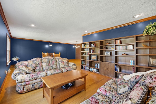 living area with a textured ceiling, ornamental molding, and wood finished floors