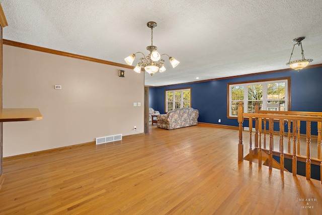 dining room featuring crown molding, a textured ceiling, a chandelier, wood finished floors, and baseboards