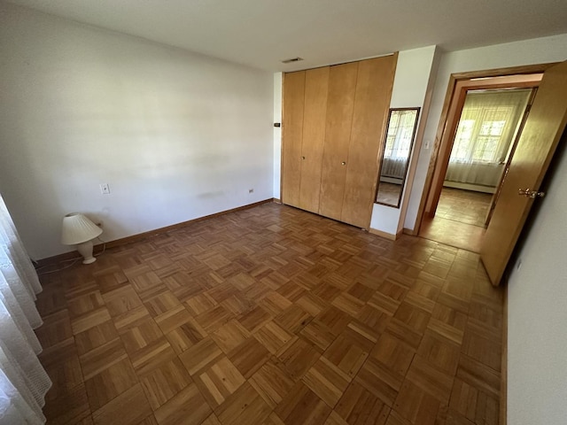 unfurnished bedroom with baseboards, a baseboard heating unit, and a closet