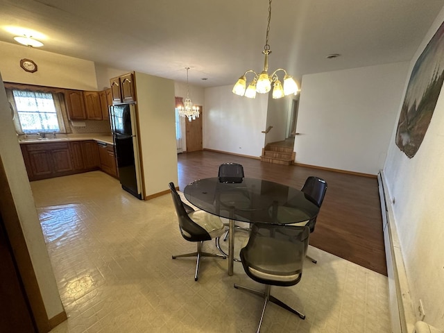 dining room with a chandelier and baseboards