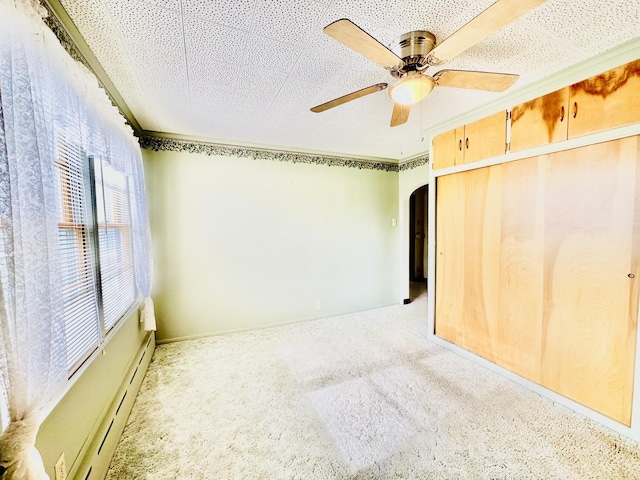 1115 E Wilson St, Streator, IL 61364 - unfurnished bedroom with arched walkways, carpet flooring, a ceiling fan, and a closet