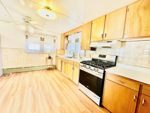 1115 E Wilson St, Streator, IL 61364 - kitchen featuring stainless steel gas range oven, under cabinet range hood, a sink, light wood-style flooring, and a baseboard radiator