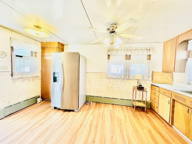 1115 E Wilson St, Streator, IL 61364 - kitchen with stainless steel fridge with ice dispenser, a baseboard heating unit, light wood-style floors, and a ceiling fan