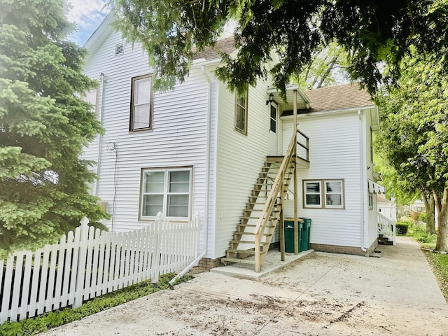 1115 E Wilson St, Streator, IL 61364 - rear view of house featuring stairway, fence, and roof with shingles