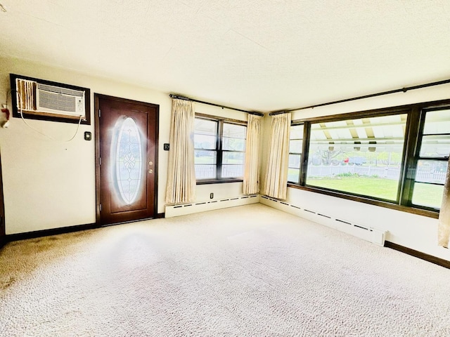 1115 E Wilson St, Streator, IL 61364 - entrance foyer featuring a wall mounted air conditioner, baseboards, carpet floors, baseboard heating, and a textured ceiling