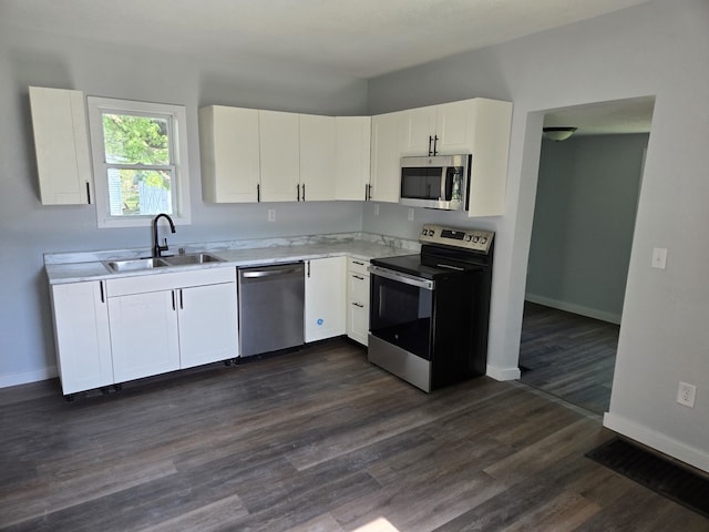 kitchen with stainless steel appliances, a sink, light countertops, and baseboards