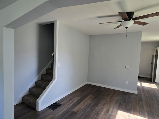 stairway featuring wood finished floors, ceiling fan, and baseboards