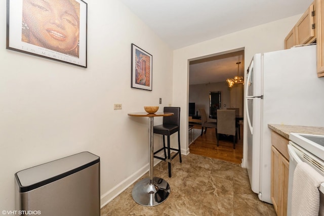 200 N Dearborn St Unit 3008, Chicago, IL 60601 - kitchen with light brown cabinetry, light countertops, white electric range oven, baseboards, and a chandelier