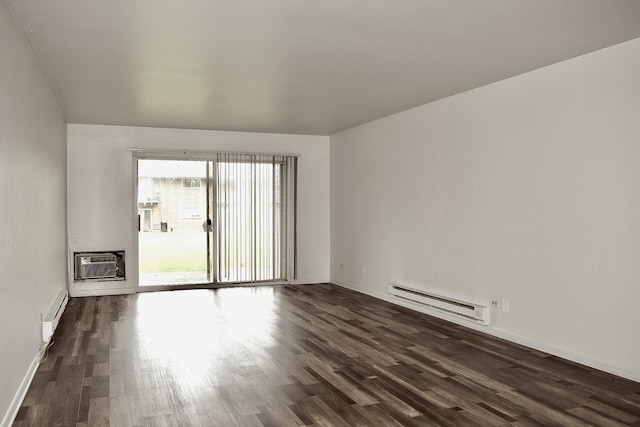unfurnished room with a baseboard heating unit, dark wood-type flooring, an AC wall unit, and baseboards