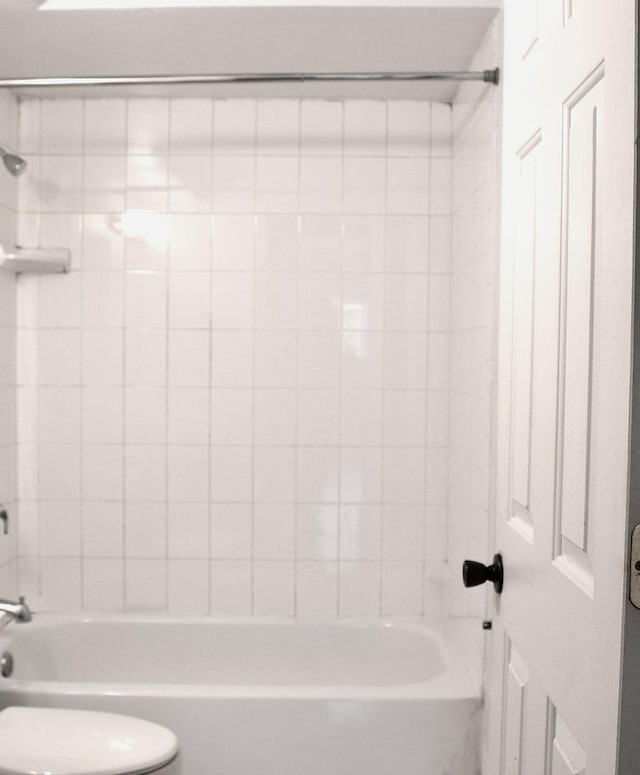 bathroom with toilet and shower / washtub combination