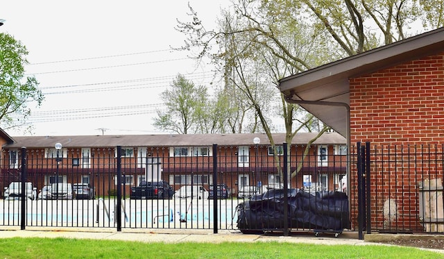 back of house featuring fence and brick siding