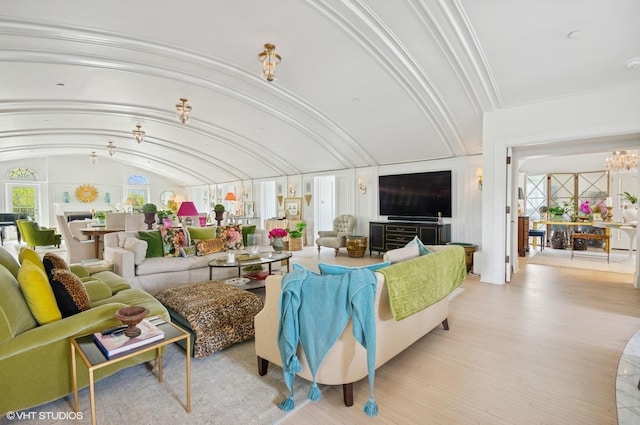 living area with vaulted ceiling and a chandelier