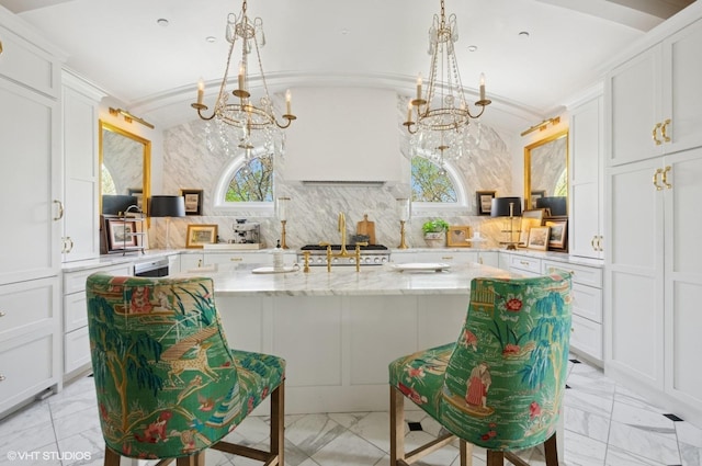kitchen featuring a chandelier, light marble finish flooring, white cabinets, and ornamental molding