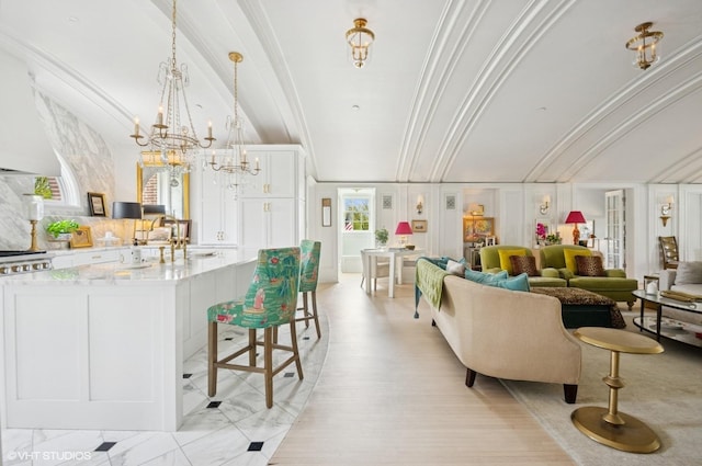 living room with crown molding, a chandelier, and light wood-style floors