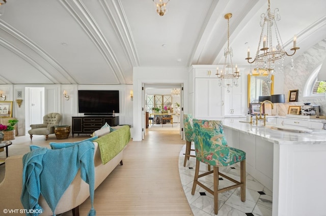 living area featuring a chandelier, beamed ceiling, and ornamental molding