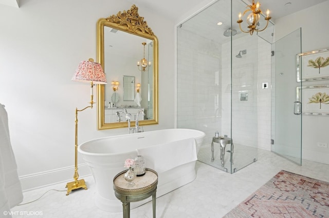 bathroom with a chandelier, a shower stall, a freestanding bath, and baseboards