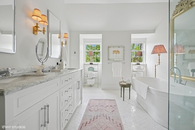 full bathroom with double vanity and a freestanding bath