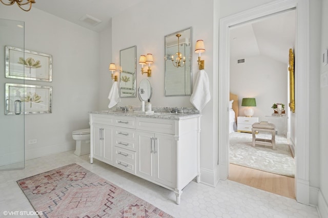 ensuite bathroom featuring a chandelier, double vanity, toilet, and lofted ceiling