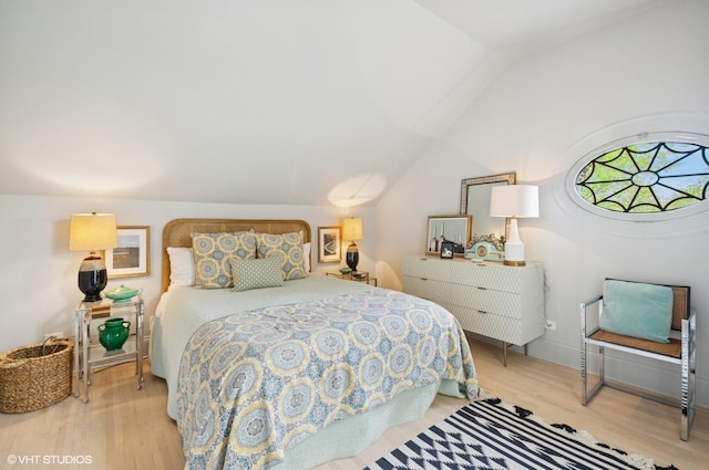bedroom featuring wood finished floors and lofted ceiling
