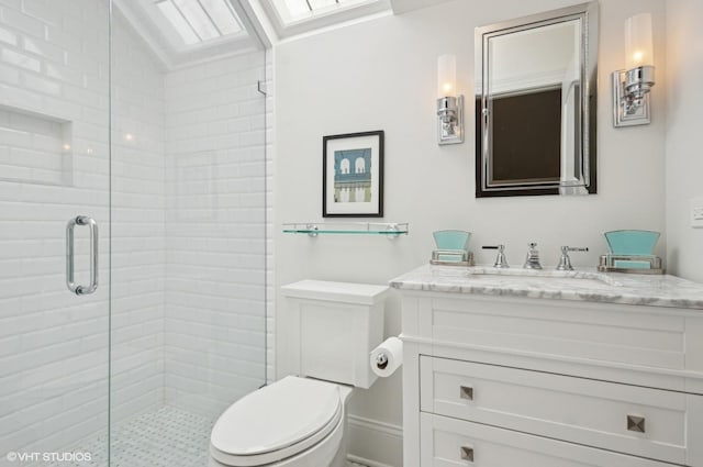 bathroom featuring a shower stall, toilet, and vanity