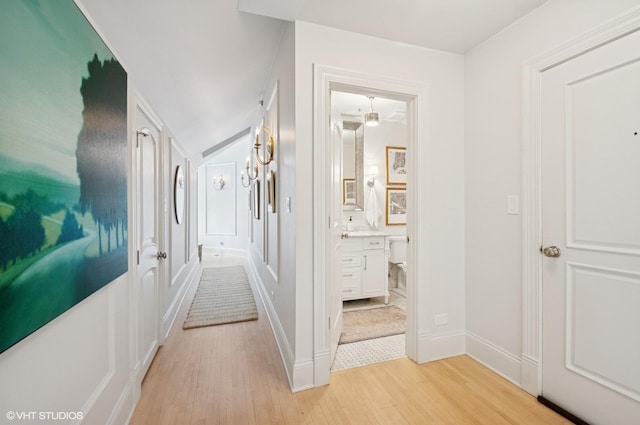 hallway with light wood finished floors and baseboards