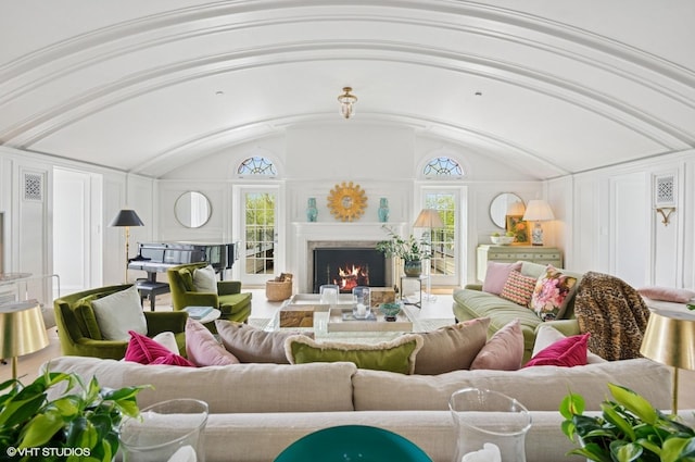 living room with a lit fireplace and lofted ceiling
