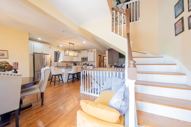 staircase with recessed lighting and wood finished floors