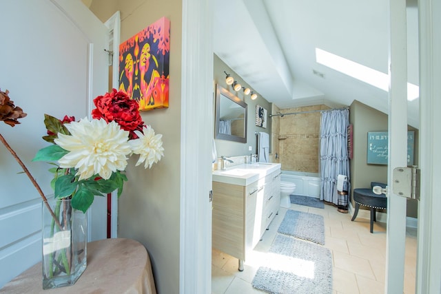 full bath featuring a skylight, lofted ceiling, shower / bath combo with shower curtain, vanity, and toilet