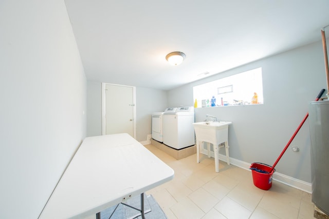 laundry room with washing machine and dryer, water heater, and baseboards