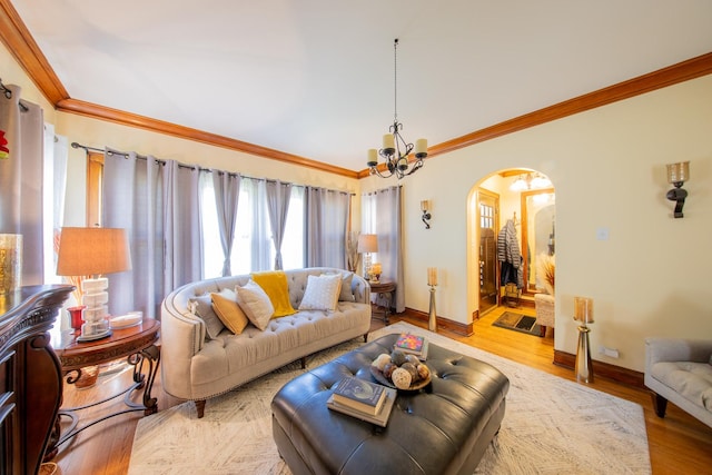 living room with arched walkways, crown molding, baseboards, a chandelier, and light wood-type flooring