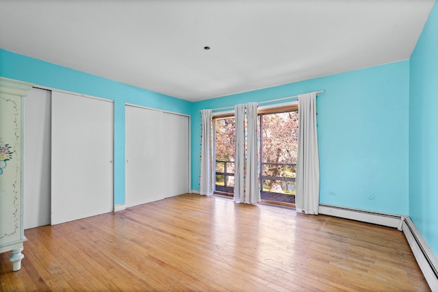 1N341 Indian Knoll Rd, West Chicago, IL 60185 - unfurnished bedroom with a baseboard radiator, hardwood / wood-style flooring, and multiple closets