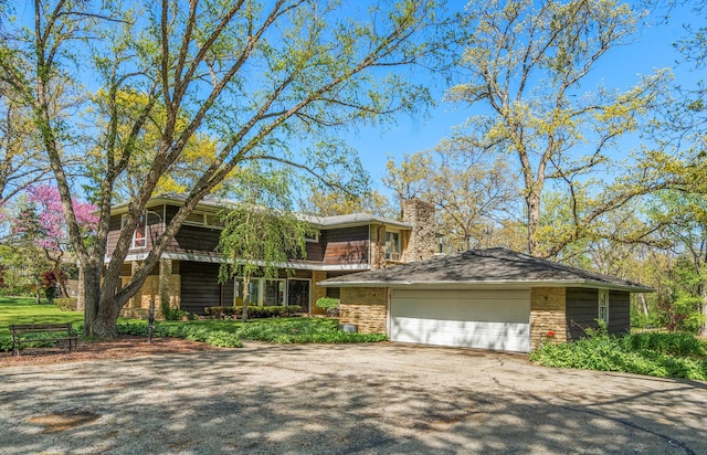 1N341 Indian Knoll Rd, West Chicago, IL 60185 - view of front facade featuring a chimney, driveway, and an attached garage