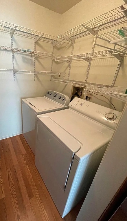 laundry area featuring washer and clothes dryer and wood finished floors