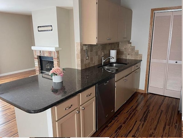kitchen featuring a sink, stainless steel dishwasher, dark wood-style floors, and baseboards