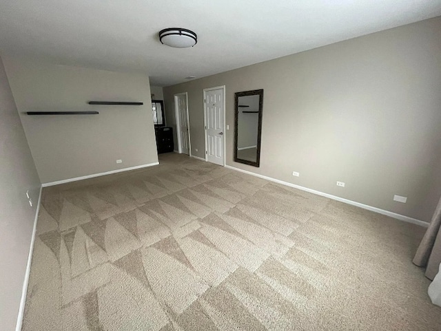 carpeted empty room featuring baseboards