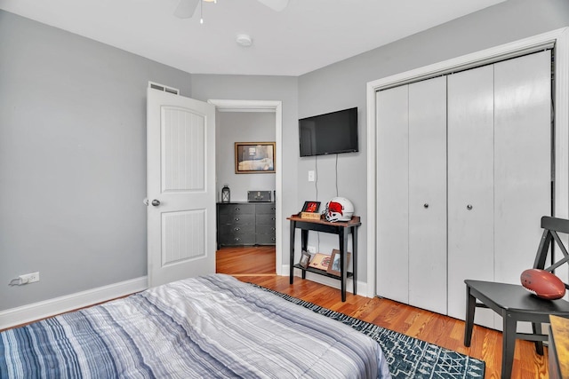 bedroom featuring wood finished floors, a closet, baseboards, and ceiling fan