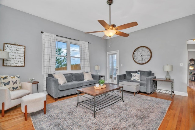 living room with a ceiling fan, wood finished floors, and baseboards