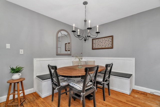 dining space with light wood finished floors, baseboards, and a chandelier