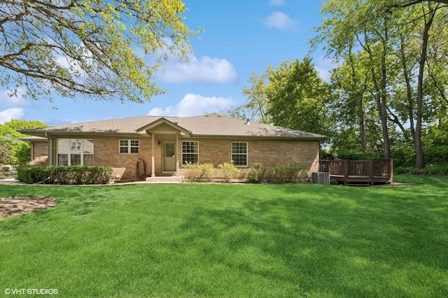 rear view of property featuring brick siding, central air condition unit, a yard, and a wooden deck
